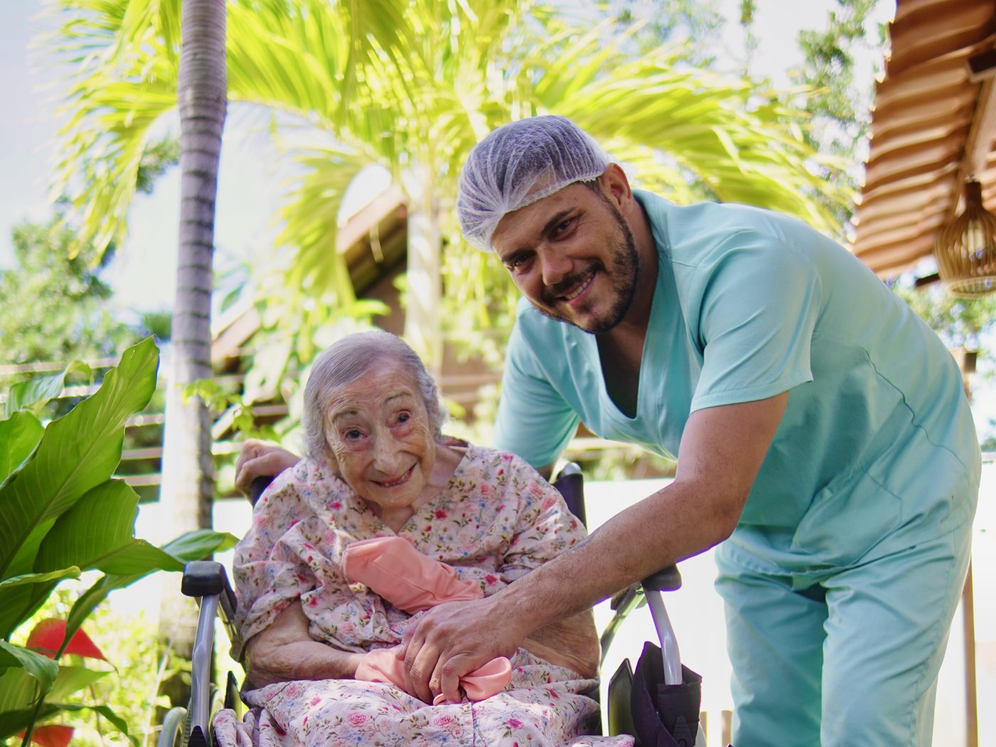 Moradora com o cuidador no jardim